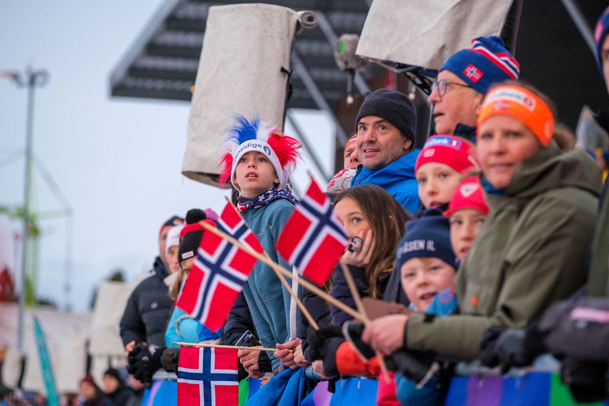 Children and adults watching a ski race.